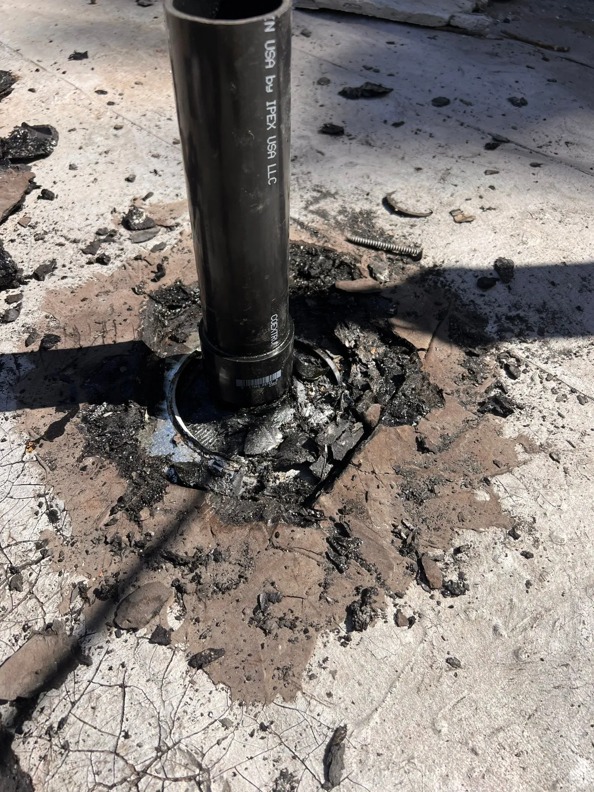 A failed, tar-sealed pipe penetration on an older roof, the kind of improvised flashing we find on Chico homes from the 1900s to 1950s